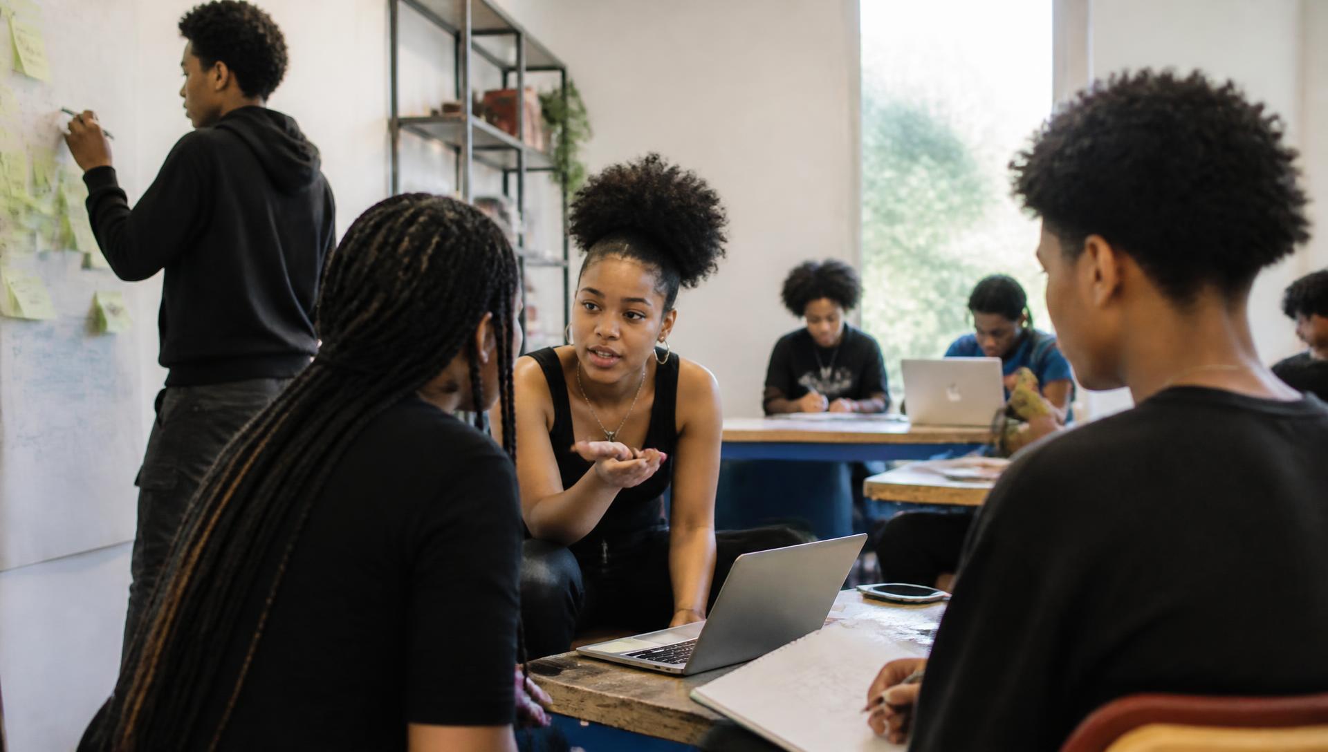 Two Black teenagers working together on a hands-on project in a community learning studio